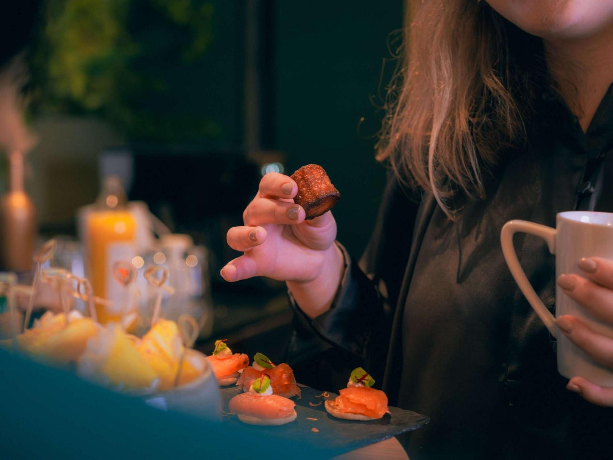 Nest Paris La Defense - Mgallery Puteaux Eksteriør bilde A woman holding a piece of sushi